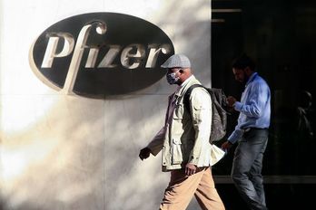 Un hombre camina por la sede mundial de Pfizer en Nueva York. (Kena BETANCUR/AFP)