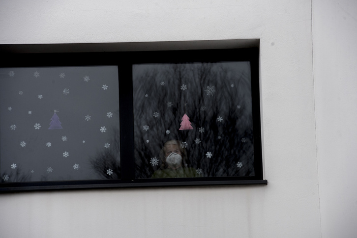 Una residente mira desde la ventana del centro donde comenzó la vacunación en Gipuzkoa.    (Gorka RUBIO I FOKU)