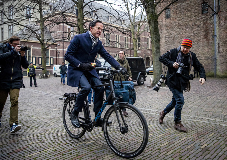 El primer ministro, Mark Rutte, llega en bicicleta a la sede del Gobierno. (Remko DE WAAL/AFP)