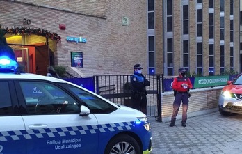 Agente de la Policía Municipal de Iruñea y de Policía Foral vigilan que nadie entre ni salga de la residencia de estudiantes de Iruñea en la que se han dado varios casos de covid. (POLICÍA MUNICIPAL DE IRUÑEA)