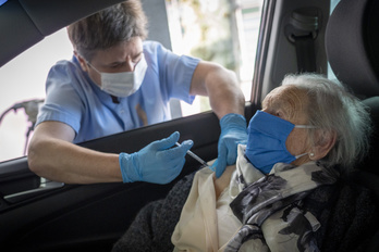 Un sanitario vacuna a una persona dentro de un coche en Donostia. (Gorka RUBIO/FOKU)