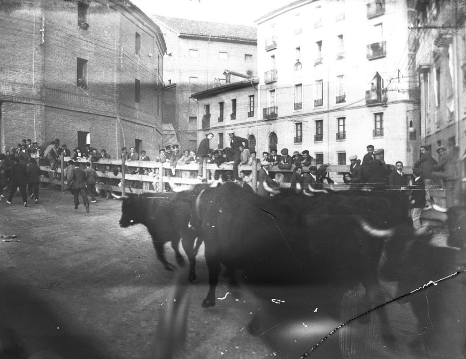 Tras salir de Estafeta, la manada enfila hacia el callejón de la vieja plaza de toros de Iruñea en un encierro de 1921. (Carlos AMAT/FOTOTECA DE NAFARROA)