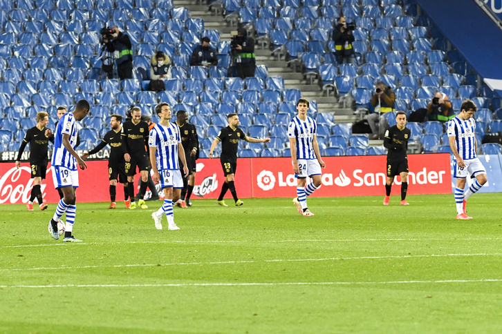 Los jugadores realistas marchan cabizbajos mientras los del Barça celebran uno de sus seis goles. (Gorka RUBIO / FOKU)