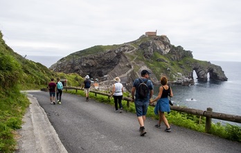 Varias personas descienden por el acceso a San Juan de Gastelugatxe, en una imagen de archivo. (Luis JAUREGIALTZO/FOKU)