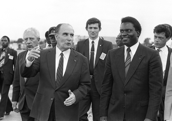 El presidente francés, François Mitterrand, conversa con su homólogo ruandés, Juvénal Habyarimana, tras aterrizar en Kigali el 10 de diciembre de 1984. (Georges GOBET | AFP)