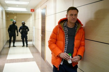 En esta fotografía, tomada el 26 de diciembre de 2019, Alexei Navalny aparece en un pasillo de la oficina de su Fundación Anticorrupción (FBK), en Moscú, custodiado por policías. (Dimitar DILKOFF | AFP)