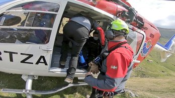 Agentes de la Ertzaintza ayudan a la persona accidentada acceder al helicóptero. (@UvrErtzaintza)