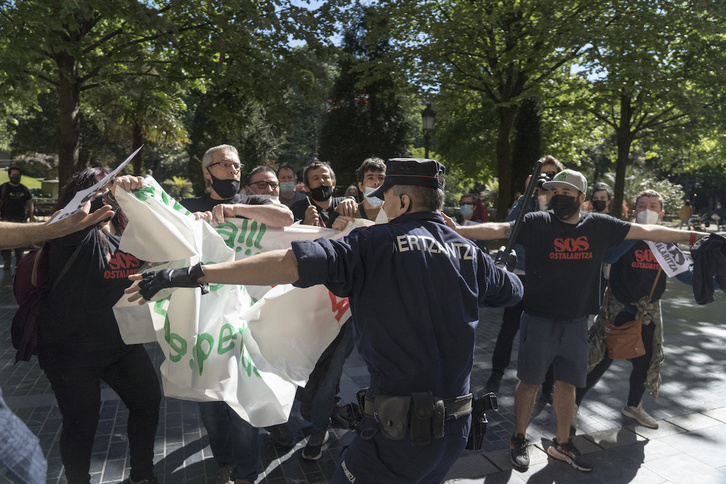 Un ertzaina blande su porra ante los hosteleros. (Gorka RUBIO / FOKU)