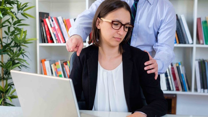 Una trabajadora de una oficina sufre la presión física y psicológica de su jefe. (youthemploymentdecade.org)