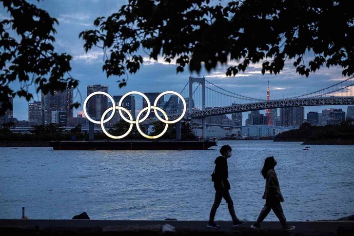una vista general de los anillos olímpicos iluminados al anochecer en el paseo marítimo de Odaiba en Tokio. (Charly TRIBALLEAU / AFP)