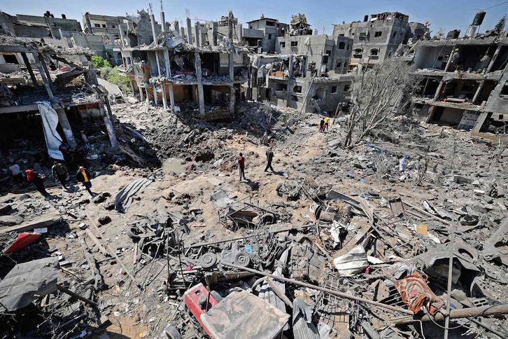Palestinos recorren las ruinas dejadas por los bombardeos en Belt Hanun. (Mahmud HAMS/AFP)