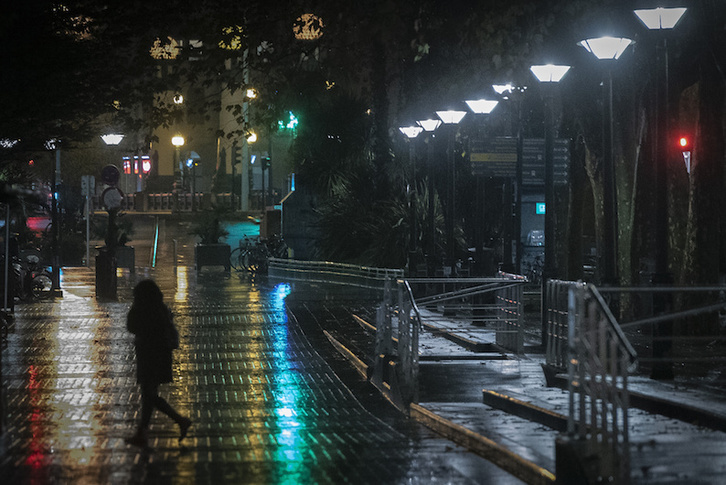 Una mujer camina por la noche por el centro de Donostia. (Gorka RUBIO/FOKU)