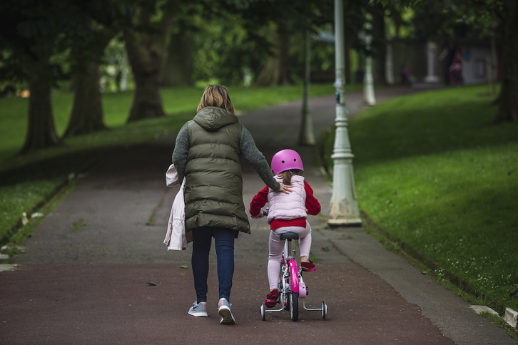 Una mujer camina con una niña por un parque de Bilbo. (Aritz LOIOLA / FOKU)