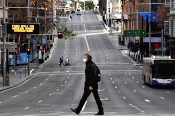 Un hombre camina prácticamente solo por una céntrica calle de Sydney. (Saeed KHAN/AFP)