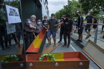 Los agentes de seguridad del edificio han retirado los ataúdes con la bandera española. (Jon URBE/FOKU)