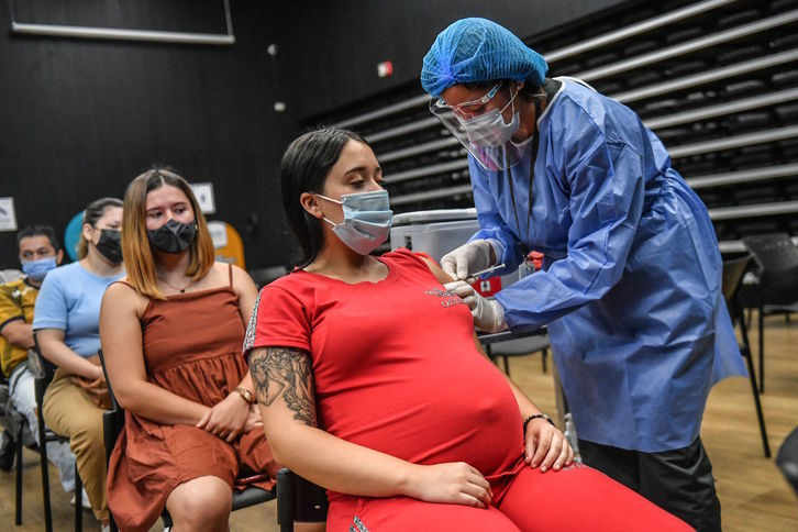 Una mujer embarazada recibe la vacuna de Pfizer en un centro de vacunación de Medellín. (Joaquín SARMIENTO/AFP)