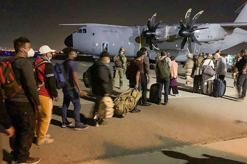 Ciudadanos franceses y colaboradores locales embarcan en Kabul en un avión fletado por París. (STR/AFP)