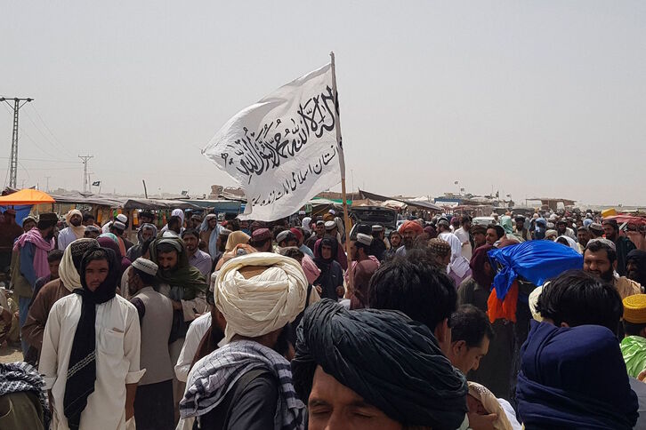 Una bandera talibán, asoma entre una multitud de hombres. (AFP)