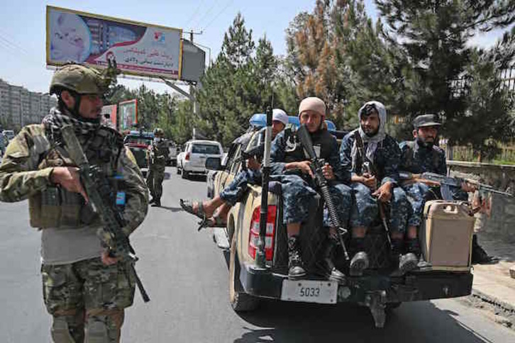 Un talibán, con uniforme regular de soldado, monta guardia junto a milicias protegiendo el aeropuerto. (Aamir QURESHI/AFP)