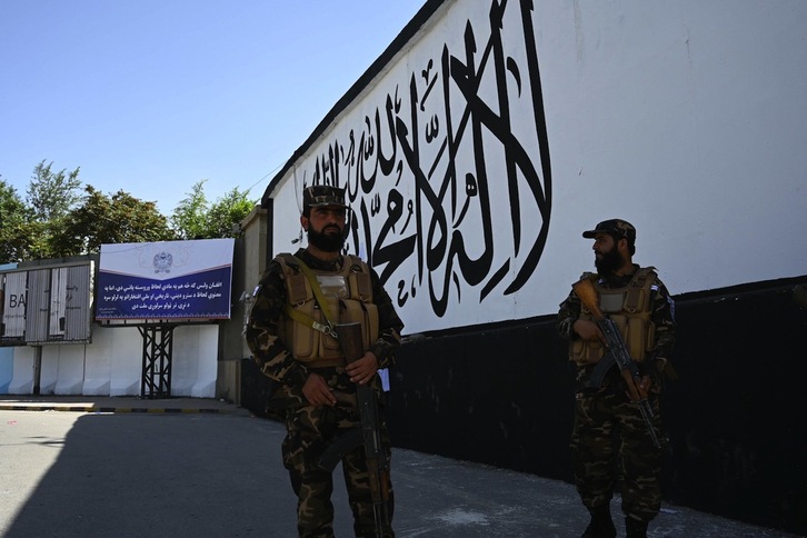 Soldados talibanes en el exterior de la embajada estadounidense, pintada con la bandera talibán. (Aamir QURESHI/AFP)