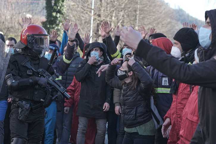 Un ertzaina frente a trabajadores de Tubacex de huelga en Laudio. (LAB AIARALDEA)