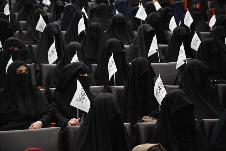 Mujeres afganas con banderas talibanas y niqab asisten a un acto del régimen en la universidad Shaheed Rabbani de Kabul. (Aamir QURESHI/AFP)