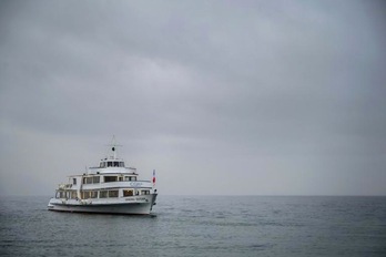 Un barco navega por el lago Lemán cerca de la ciudad suiza de Ginebra. (Fabrice COFFRINI/AFP)