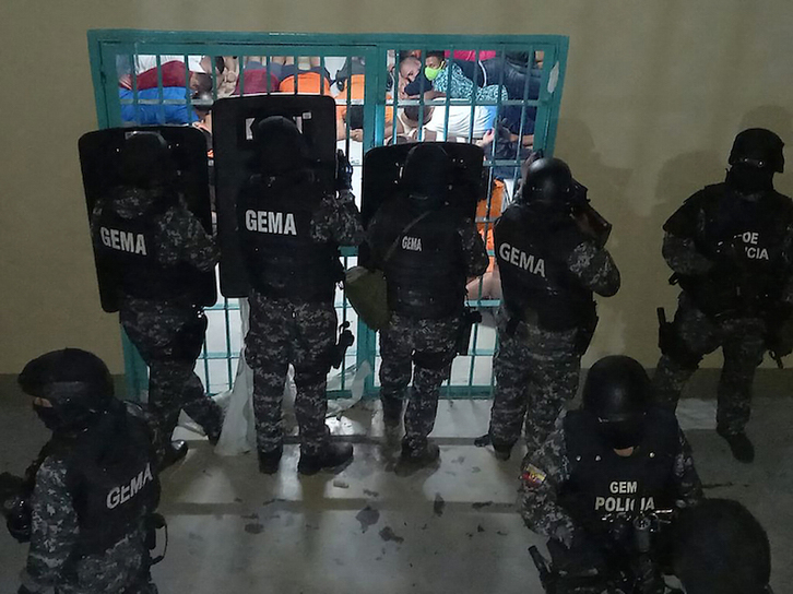 Miembros del GEMA (Grupo Especial Móvil Antinarcóticos) vigila a los presos tirados en el suelo. (Fernando MÉNDEZ/AFP)