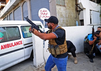 Un miliciano de Amal se parapeta tras una ambulancia. (ANWAR AMRO-AFP)