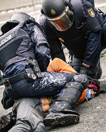 Dos agentes de la Policía española detienen a Guillem Padilla durante las protestas postsentencia. (GUILLEM ABSOLUCIÓ)