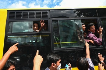 Prisioneros excarcelados saludan a los suyos desde el autobús. (STR-AFP)