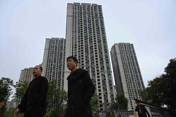 Gente pasando frente a un complejo de viviendas de la promotora inmobiliaria Evergrande en Kunming, en la provincia de Yunnan. (Jade GAO/AFP)