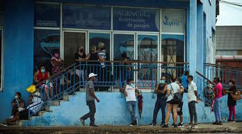 Un grupo de personas hace cola ante una agencia de viajes de La Habana. (YAMIL LAGE / AFP)