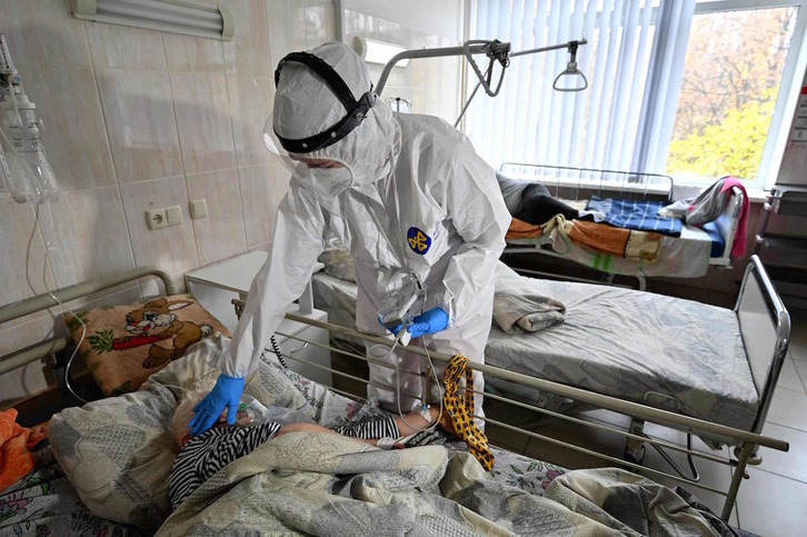 Personal sanitario atiende a una mujer con covid-19 en un hospital de Ucrania. (SERGEI SUPINSKY / AFP)