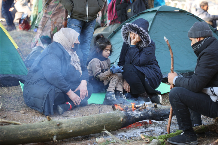 Una de las muchas familias atrapadas con temperaturas gélidas entre Polonia y Bielorrusia. (Leonid SHCHEGLOV  / AFP)