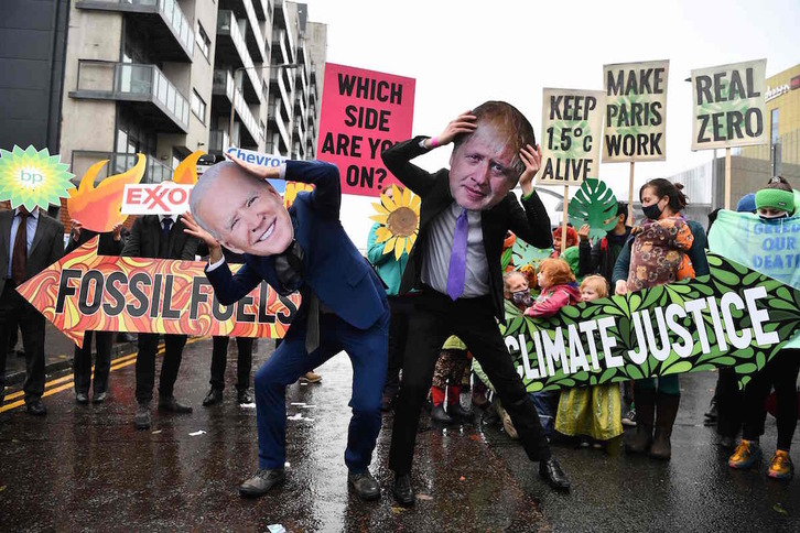 Manifestantes en Glasgow, con máscaras del presidente de EEUU, Joe Biden, y dle primer ministro británico, Boris Johnson. (Ben STANSALL/AFP)