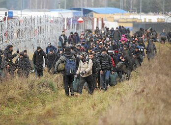 Migrantes caminan por la frontera en el lado bielorruso. (Leonid SCHEGLOV/AFP)