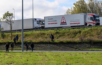 Un grupo de migrantes camina junto a la autopista en las inmediaciones de Calais. (DENIS CHARLET / AFP) 