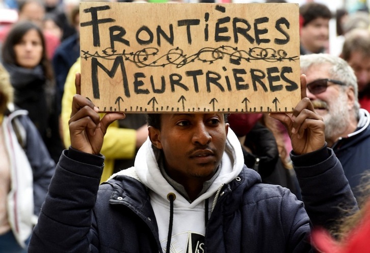 Un hombre sostiene un cartel que denuncia las «fronteras asesinas» durante una manifestación en apoyo a los migrantes en Calais, en el norte del Estado francés. (François LO PRESTI/AFP)