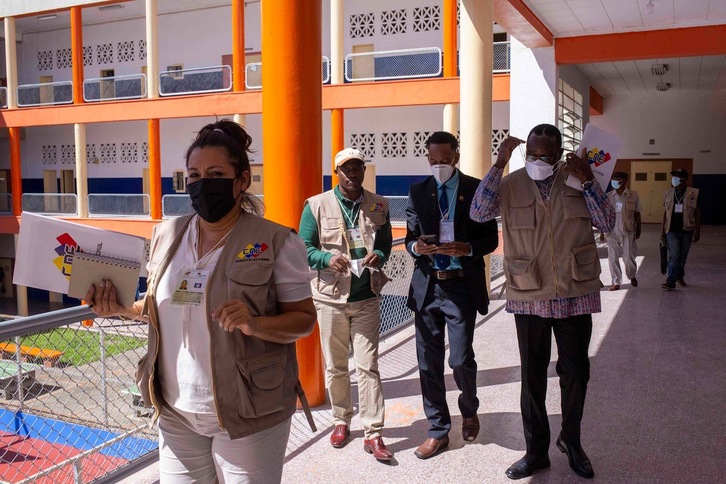 Integrantes de una misión de observación internacional, en un colegio electoral de Caracas. (Cristian HERNANDEZ/AFP)