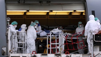 Personal médico en un avión de las Fuerzas Armadas alemanas preparándose para transportar a pacientes de covid a otras UCI del país, el miércoles, en el aeropuerto de Dresde. (Ronny HARTMANN/AFP)