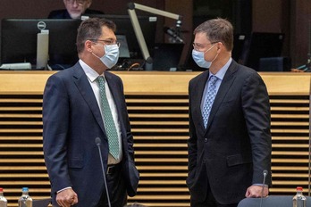 El responsable de Comercio, Valdis Dombrovskis, a la derecha, charla con el comisario Janez Lenarcic. (Olivier MATTHYS/AFP)