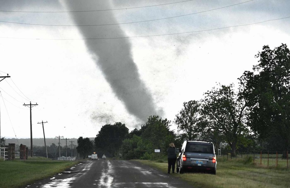 Una mujer observa mientras un tornado arrasa una zona residencial después de tocar tierra al sur de Wynnewood, Oklahoma. (Josh EDELSON/AFP)