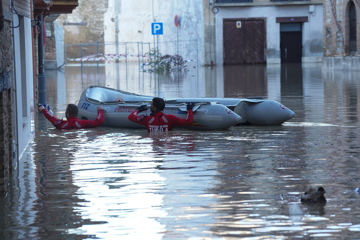 Dos miembros de protección civil realizando labores de evacuación en Tutera. (Jagoba MANTEROLA/FOKU)