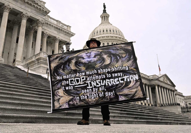 Un hombre sostiene un cartel denunciando la responsabilidad de los republicanos, ante las escalinatas del Capitolio, en Washington.