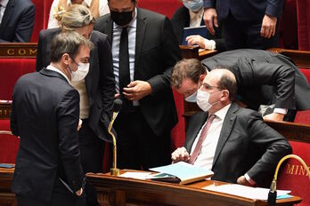 El ministro francés de Sanidad, Olivier V´ran, habla durante un receso de la sesión, con el premier Jean Castex. 