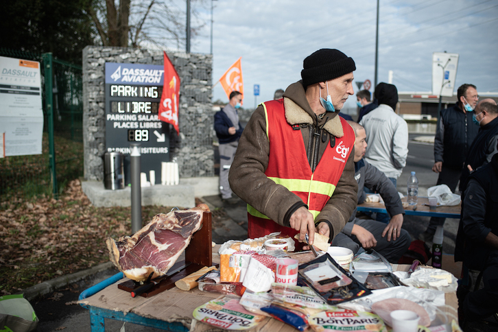 Un huelguista prepara el almuerzo con el que hacer frente a una jornada heladora a las puertas de la factoría de Dassault, en Angelu.