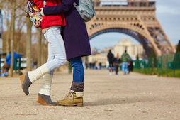 Una pareja de chicas se abraza ante la torre Eiffel. 
