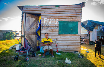 Un hombre posa junto a su vivienda en Nuevo Comienzo.