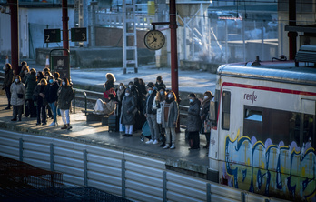 Un grupo de personas, todas con mascarilla, aguarda a la llegada del tren en Donostia.         